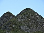 43 Zoom sul Monte Tribortoti (2300 m) con  escursionisti alla croce e pecore al pascolo